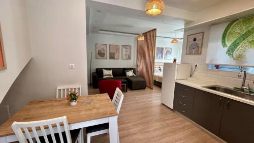 cocina y sala de estar con mesa, cocina y sofá en Καλαίσθητο Ηλιόλουστο Studio, en La Canea