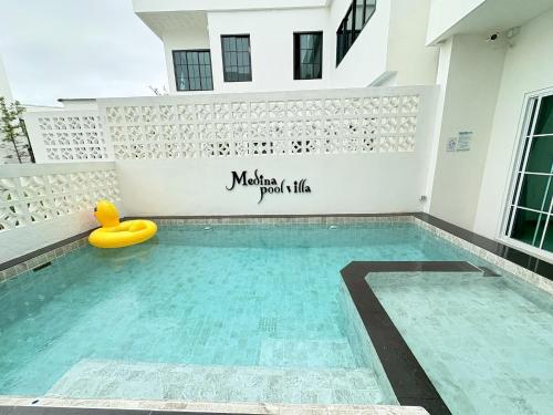 a swimming pool with a yellow raft in the middle of a building at Medina Private Pool Villa-บางแสน in Ban Puk (1)