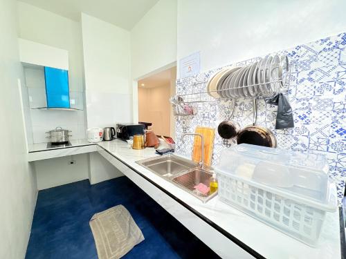 a kitchen with a sink and a dish drying rack at Medina Private Pool Villa-บางแสน in Ban Puk (1)