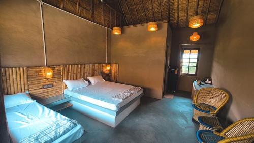 a bedroom with two beds and two chairs at The Cottage Core Village in Borās