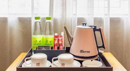 a tray with a tea kettle and cups on a table at Borrman Hotel Xiamen Xiang'an Maxiang in Xiamen