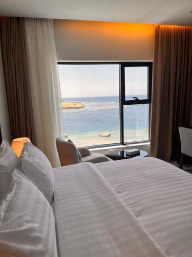 a hotel room with a bed and a view of the ocean at شقق همس البحر Hams Apartments in Ḑubā