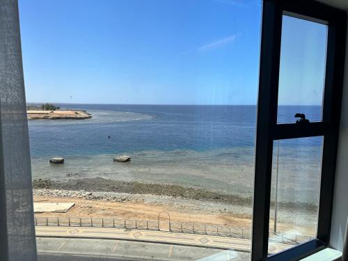 a view of the ocean from a window at شقق همس البحر Hams Apartments in Ḑubā