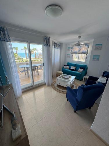 a living room with blue furniture and a view of the ocean at Marina d'Or - Vue frontale sur mer in Oropesa del Mar