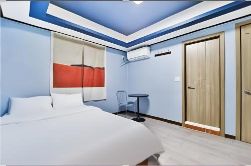a bedroom with a white bed and blue ceilings at stayaroma in Seoul