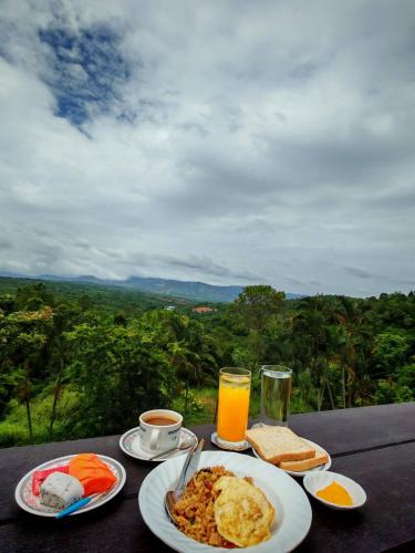 een tafel met borden vol eten en sinaasappelsap bij Phuphamok Valley Resort in Ban Na Dan