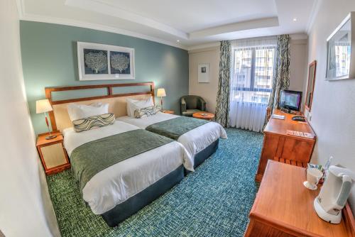 um quarto de hotel com uma cama grande e uma secretária em City Lodge Hotel Umhlanga Ridge em Durban