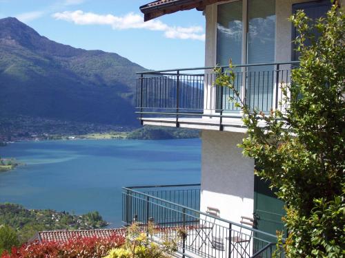 a building with a balcony overlooking a lake at Casa delle Camelie in Sorico