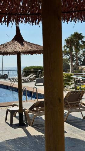 a group of chairs and umbrellas next to a pool at Apartamentos Santa Clara in Calpe