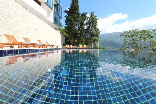 a swimming pool at a hotel with chairs and water at Apartments Aqua in Budva