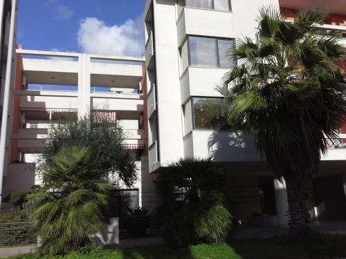 um edifício branco com palmeiras em frente em Sunny em Lecce