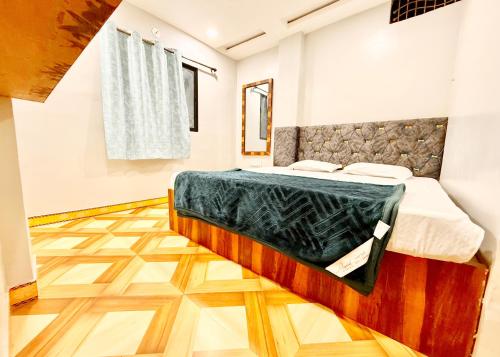 a bedroom with a bed and a wooden floor at Near Mahakal Temple # Hotel D-e-m-a-n-d ! ujjain, All Room Air conditioned And Spacious, with Wifi -BEST HOTEL IN UJJAIN in Ujjain