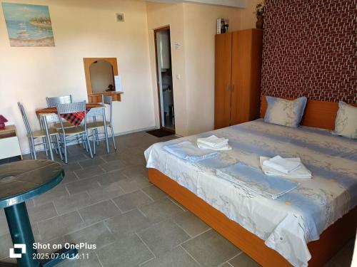 a bedroom with a bed and a table and chairs at Вила Фернандес in Chernomorets