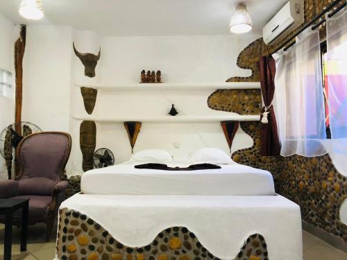 a bedroom with two beds with a table and a chair at Hotel LE BOEUF in Mandriankeniheny