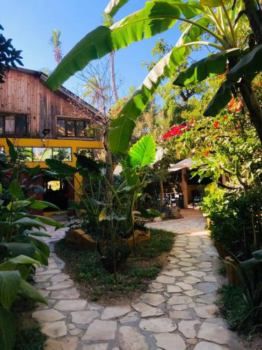 a walkway through a garden with plants and a building at Hotel LE BOEUF in Mandriankeniheny