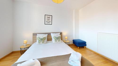 - une chambre avec un grand lit blanc et une chaise bleue dans l'établissement Les Cordonniers, à Colmar