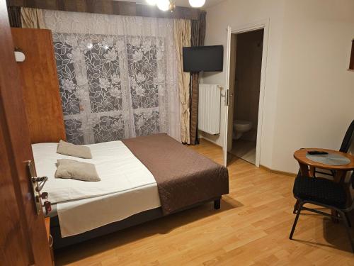 a bedroom with a bed and a table and a television at Noclegi Węgierska Górka in Węgierska Górka