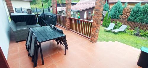a patio with a table and chairs on a balcony at Dovolenkovy dom s terasou in Spišská Nová Ves