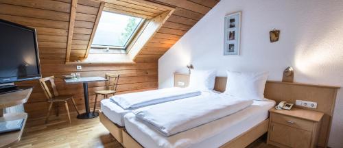 a bedroom with a large bed and a television at Gästehaus-Pension Barbara in Andelsbuch