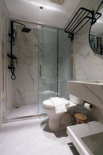 a bathroom with a shower and a toilet and a sink at Banana Guesthouse South Pattaya in Pattaya