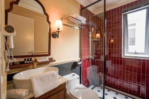 a bathroom with a toilet and a sink and a shower at Maison d'An - Boutique Hotel in Da Lat