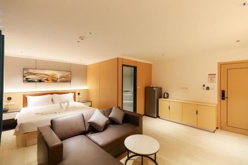 une chambre d'hôtel avec un lit et un canapé dans l'établissement Banana Guesthouse South Pattaya, à Pattaya