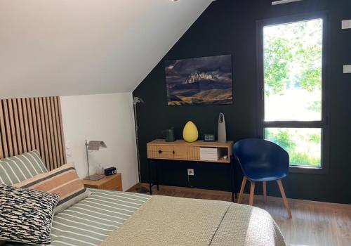 a bedroom with a bed and a desk with a chair at Chambre du mont saint Michel in Bacilly