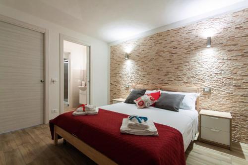 sypialnia z dużym łóżkiem z ceglaną ścianą w obiekcie Estuario rooms w mieście Castellammare del Golfo