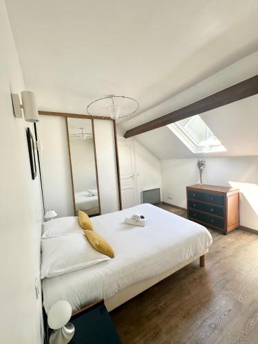 - une chambre avec un grand lit blanc et une commode dans l'établissement Maison & jardin proche Disney, Paris, Val d'Europe, à Meaux