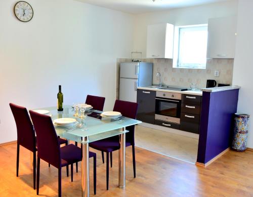a kitchen and dining room with a table and chairs at Apartments M&B in Podstrana