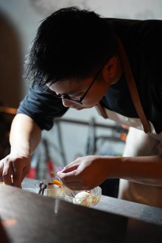 a man in glasses preparing food on a table at Shu Sia in Hengchun