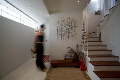 a woman walking down a hallway with a painting on the wall at Shu Sia in Hengchun
