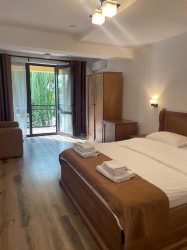 a bedroom with a large bed with towels on it at Casa Vlad in Murighiol