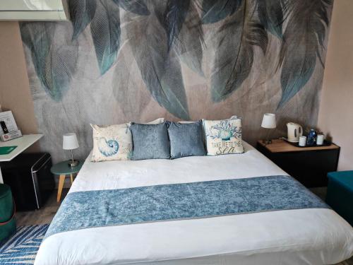 a bedroom with a bed with a mural on the wall at Boutique Hôtel de la Corniche d'Or in Mandelieu-la-Napoule