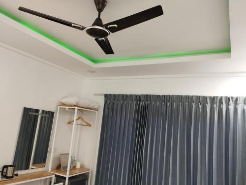 a ceiling fan in a room with a curtain at Himandhoo sweet dreams in Himandhoo 