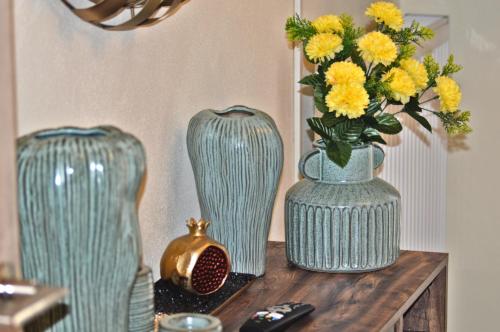 two vases sitting on a table with yellow flowers at Sweet Retreat in Dispilio