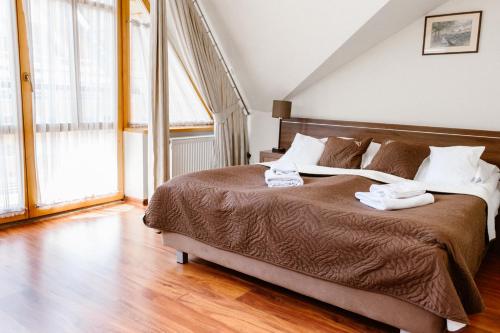 a bedroom with a large bed with towels on it at Aparthotel Bellamonte in Zakopane