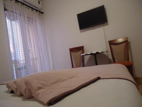 a bedroom with a bed and a flat screen tv at Apartments Villa Mićunović in Herceg-Novi
