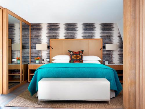 a bedroom with a large bed with a green blanket at The Marylebone Hotel in London