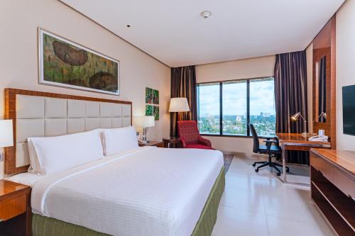 a hotel room with a bed and a desk and a computer at Holiday Inn Cochin by IHG in Cochin