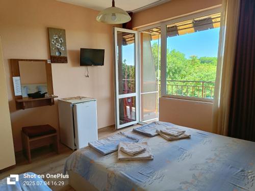 ein Schlafzimmer mit einem Bett und einem großen Fenster in der Unterkunft Вила Фернандес in Tschernomorez