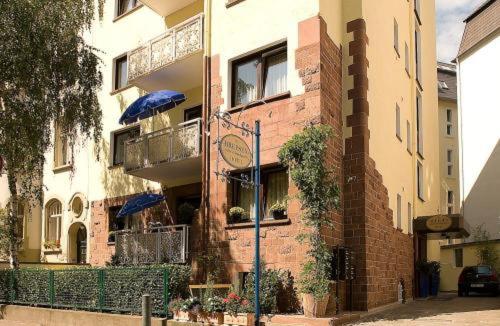 een bakstenen gebouw met blauwe parasols ervoor bij Hotelgarni Frankfurt in Frankfurt am Main