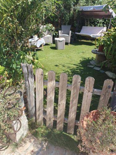 a wooden fence in a yard with a garden at Casa Elisa in Flumini di Quartu