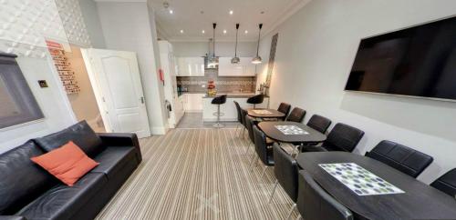 a living room with black leather furniture and a kitchen at Comfotel GRN in London