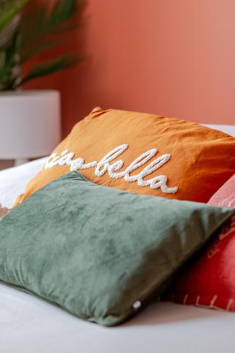 a pillow with the team written on it on a bed at Le Chaleureux - 5 min Disneyland - Parking - Netflix - Wifi in Serris