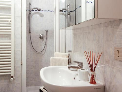 y baño blanco con lavabo y ducha. en Studio Santa Maria Novella, en Florencia