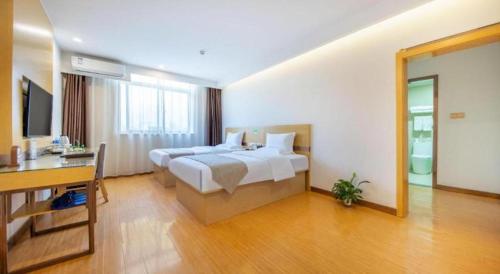 a hotel room with a bed and a desk and a desk at GreenTree Inn Huayin Huashan Town Huashan Scenicspot Express Hotel in Huayin