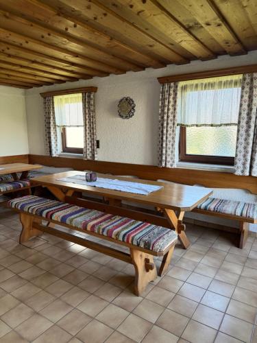 a room with benches and a table and windows at gemütliches Vierbettzimmer in Größing