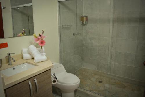 uma casa de banho com um chuveiro, um WC e um lavatório. em El Lugar Boutique Hotel em Pereira