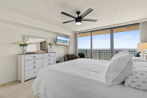 Un dormitorio con una cama blanca y una ventana grande. en Sherwin Condominium 1801, en Daytona Beach Shores